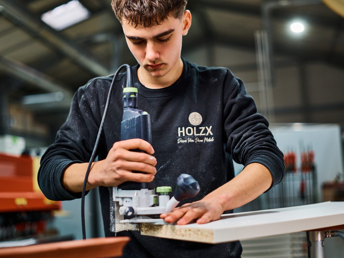 Auszubildender arbeitet mit der Oberfräse – HolzX