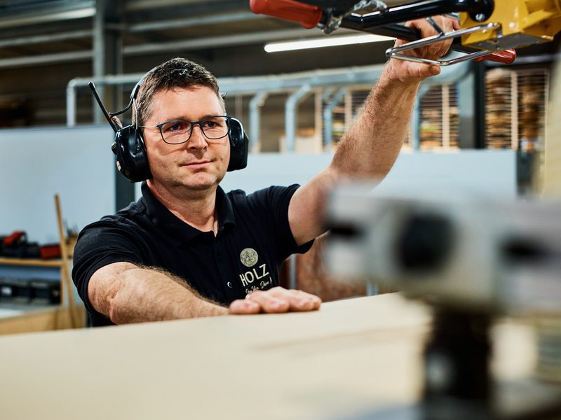 Mitarbeiter an der Kantenanleimmaschine – HolzX