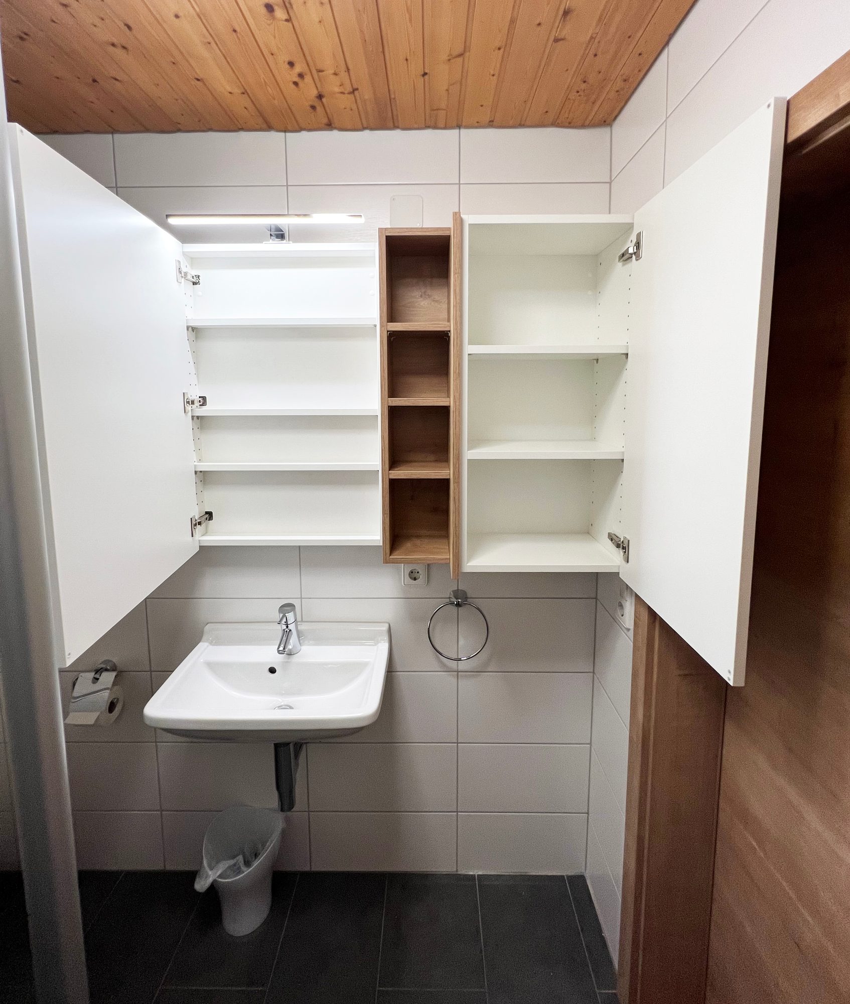 Geöffneter Spiegelschrank mit Fachböden