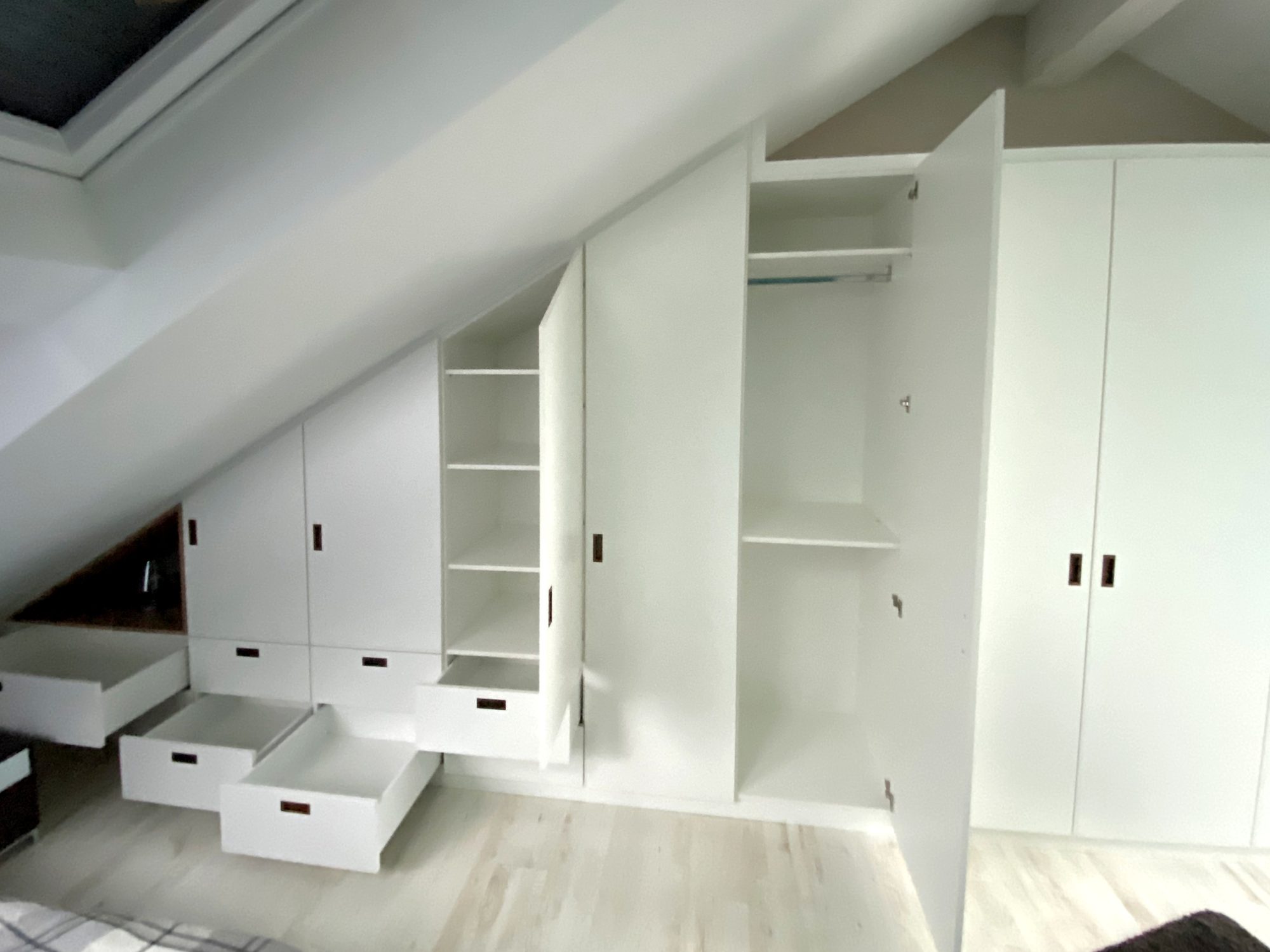 Geöffneter Einbauschrank mit Fächern und Kleiderstange