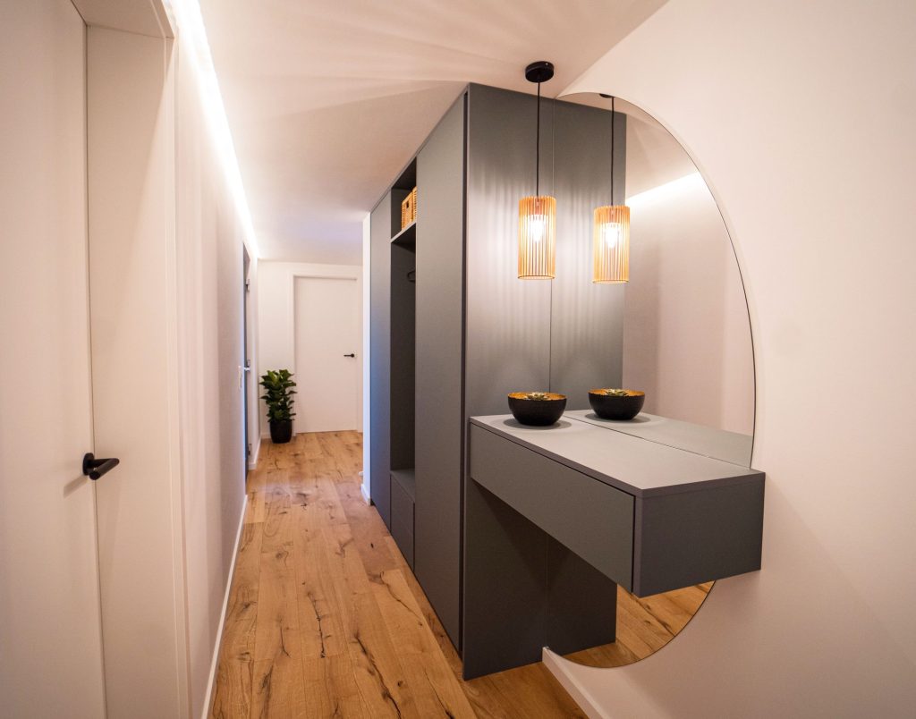 Flur mit Garderobenschrank, Ablage und rundem Spiegel