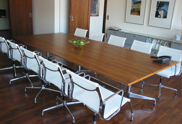Konferenztisch mit Holzoberfläche im Besprechungszimmer einer Kanzlei