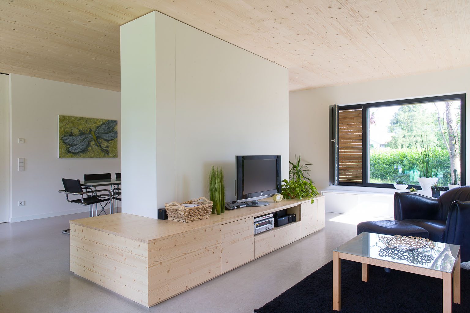 Raumteiler-Schrank mit Lowboard aus hellem Holz im Wohnzimmer