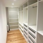 Langer Ankleidegang mit Regalen zu beiden Seiten
