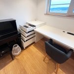 Schreibtisch mit Rollcontainer am Fenster