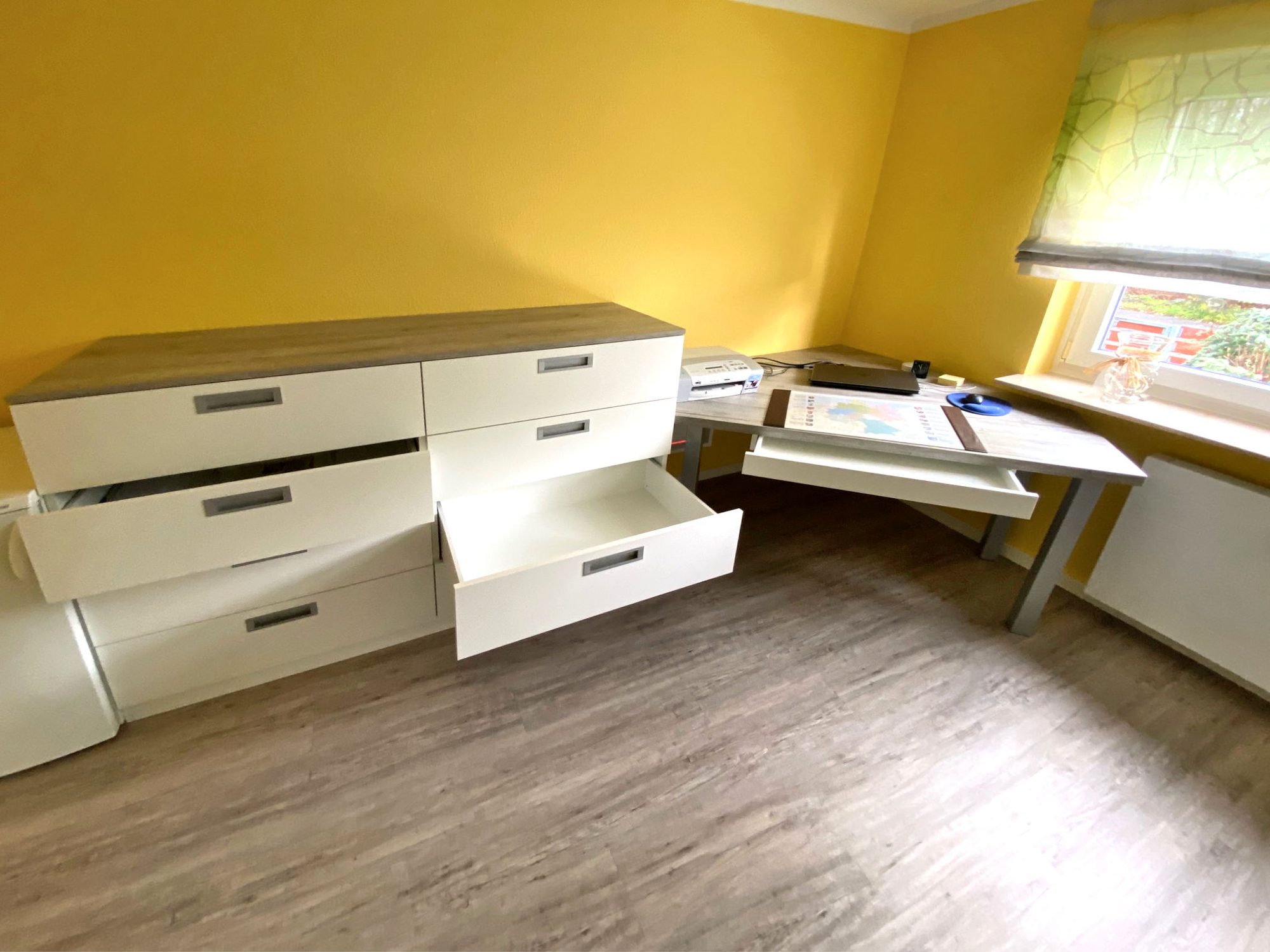 Kommode und Schreibtisch mit geöffneten Schubkästen