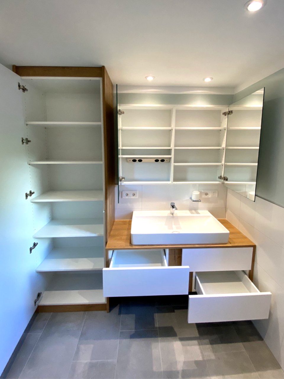 Geöffneter Hochschrank und Spiegelschrank mit Fächern