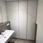 Weißer raumhoher Einbauschrank neben dem Waschbecken