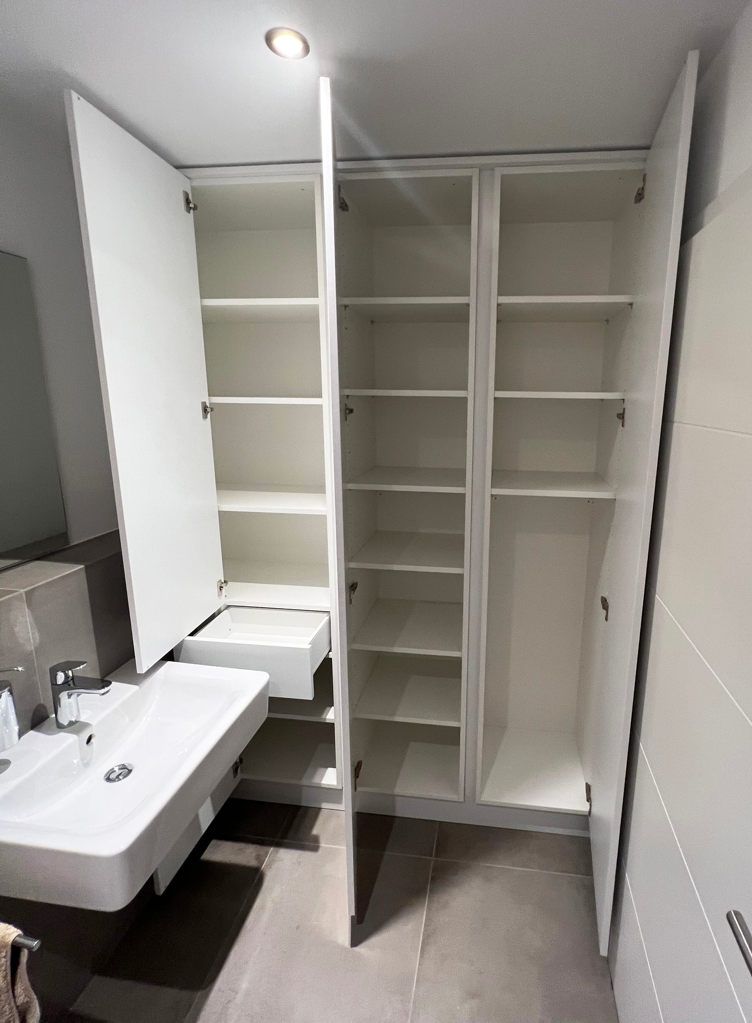 Geöffneter Einbauschrank mit Fachböden und Auszug