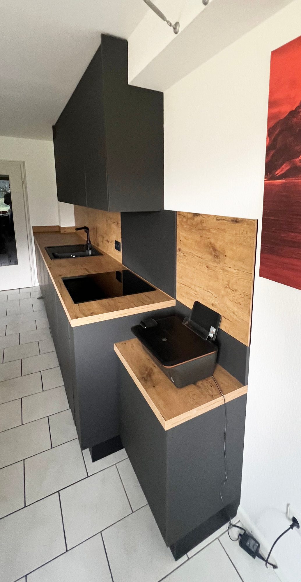 Lange dunkle Küchenzeile mit Arbeitsplatte in Holzoptik
