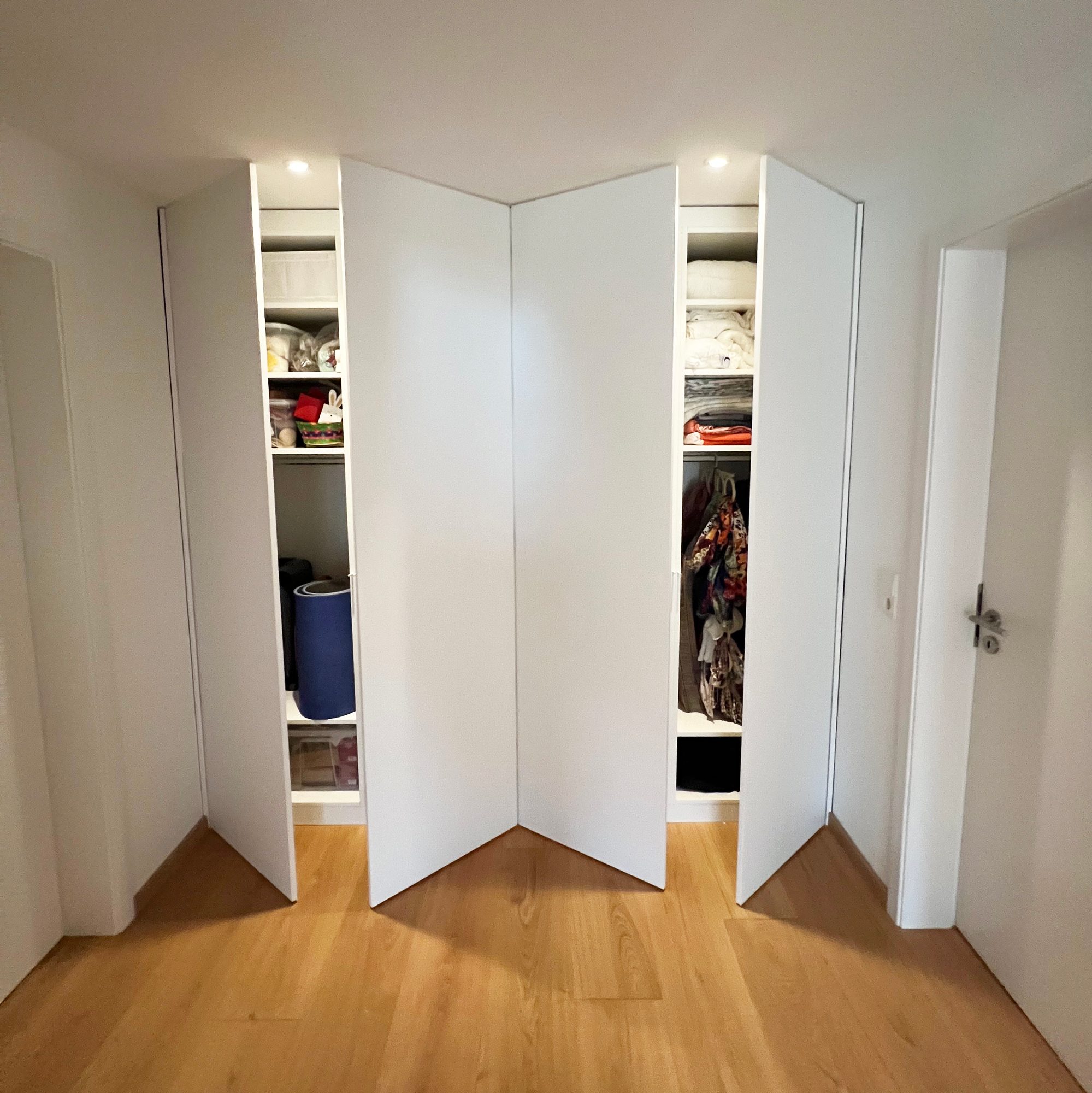 Geöffneter Einbauschrank mit Fächern und Kleiderstange