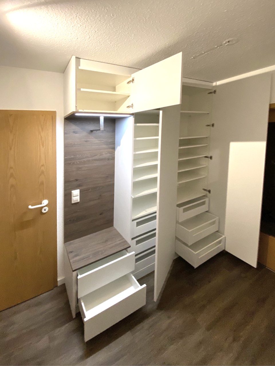 Garderobe mit geöffneten Auszügen und Hängeschrank