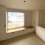 Fenstersitzbank zwischen weißen Hochschränken