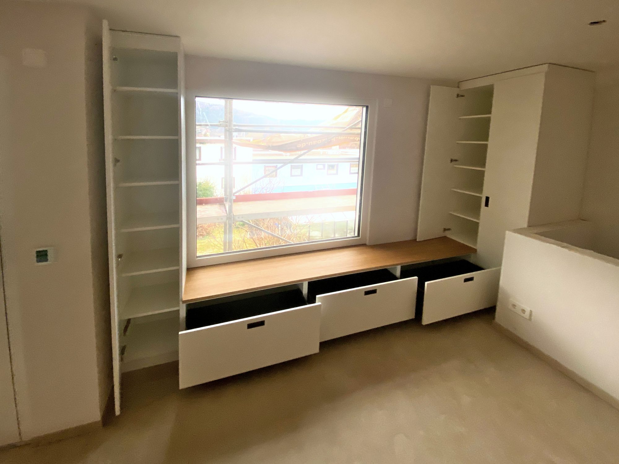 Geöffnete Schubkästen und Hochschränke mit Fachböden