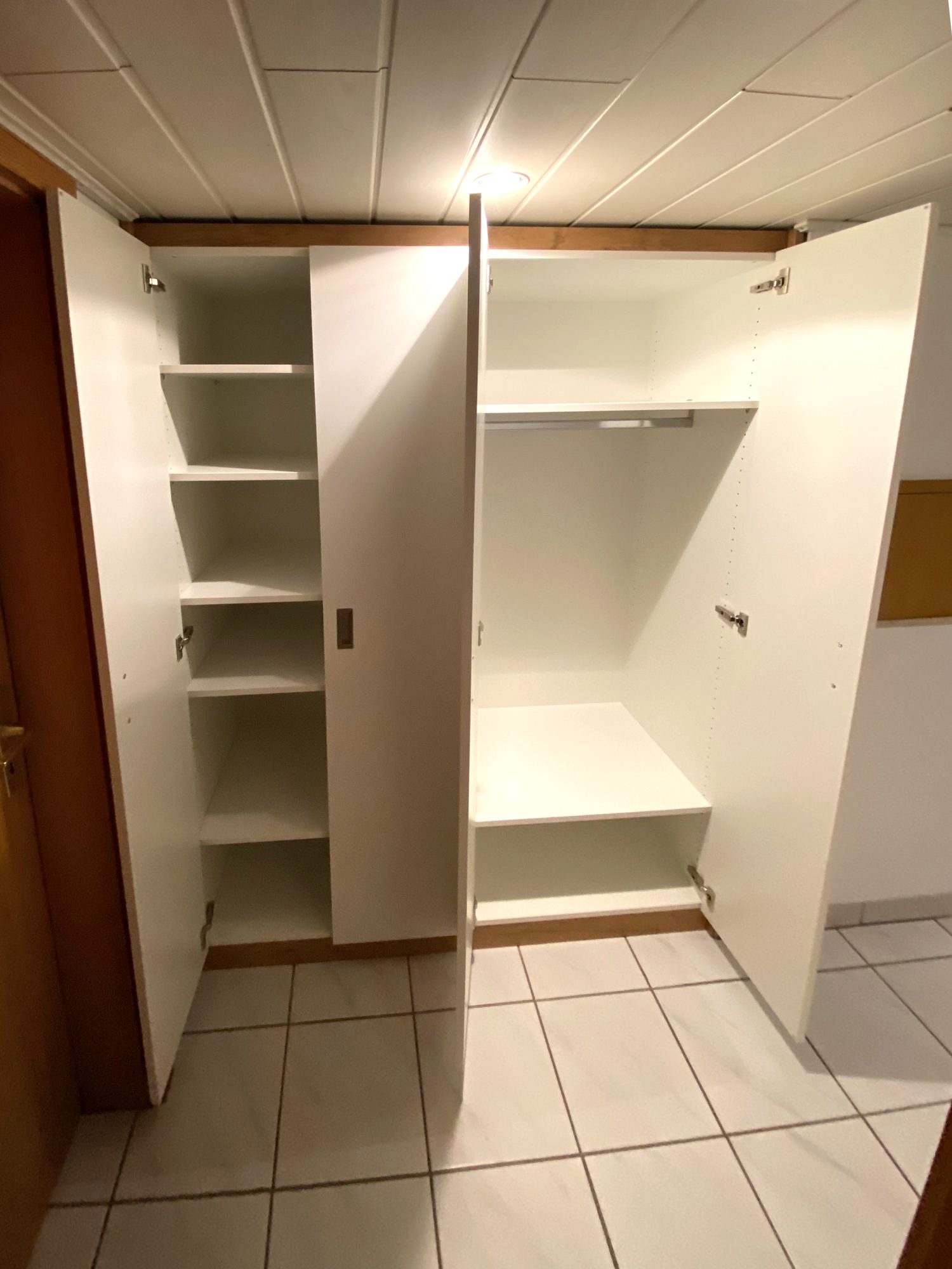 Geöffneter Flurschrank mit Fächern und Kleiderstange
