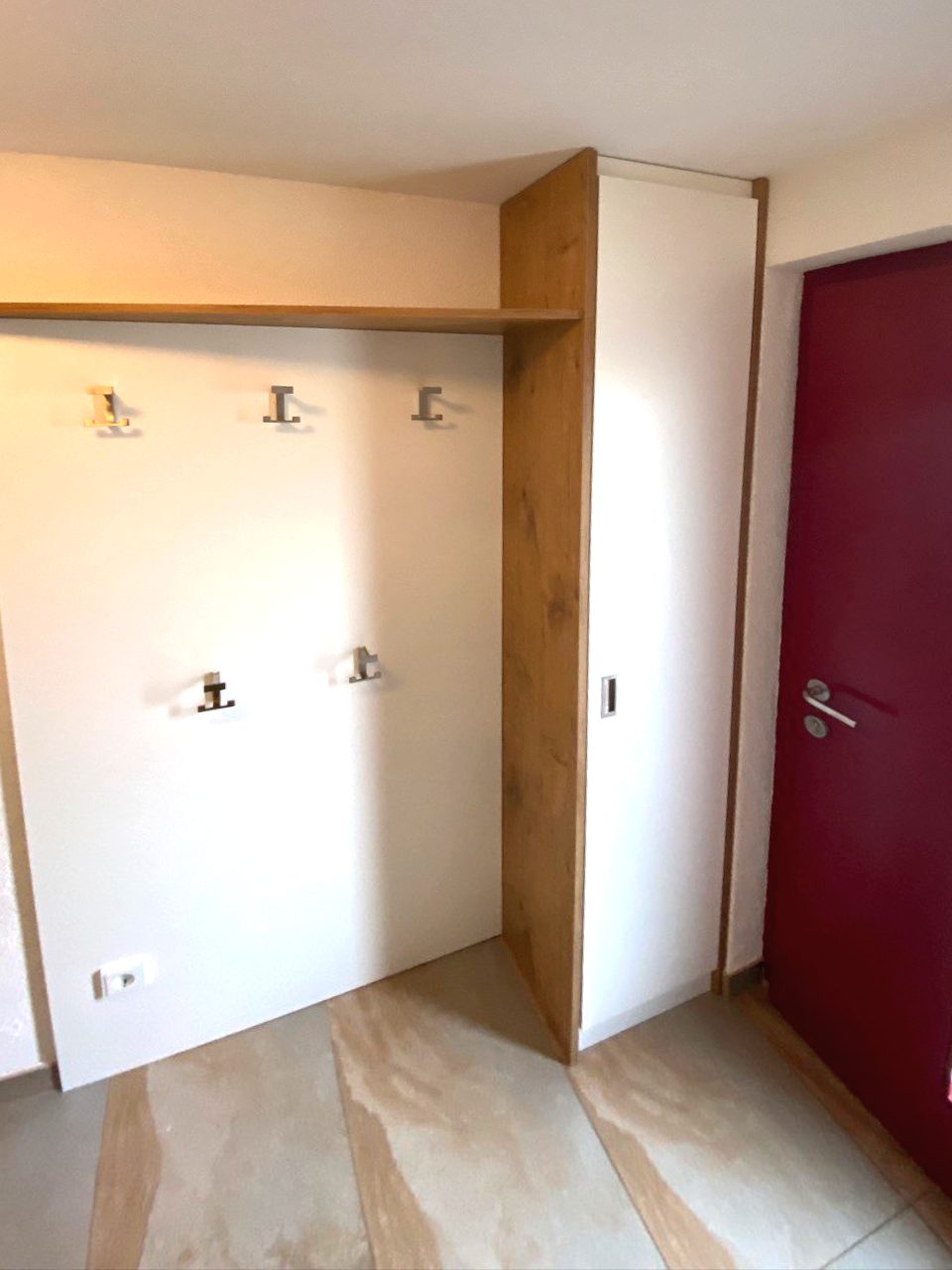 Hakenwand mit Rahmen in Holzoptik neben der Haustür