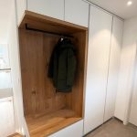 Garderobennische in Holzoptik mit Jacke an der Kleiderstange