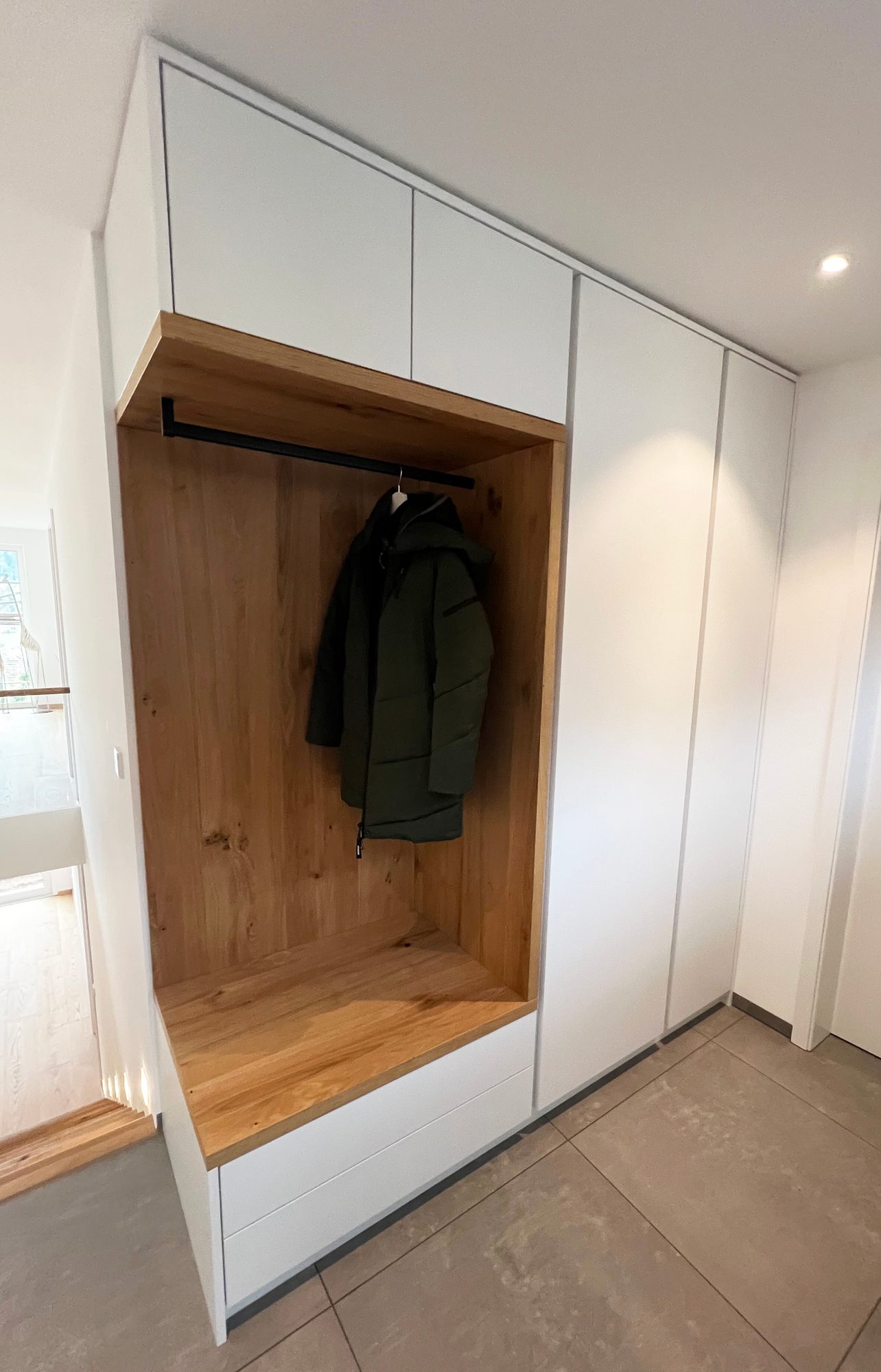 Garderobennische in Holzoptik mit Jacke an der Kleiderstange