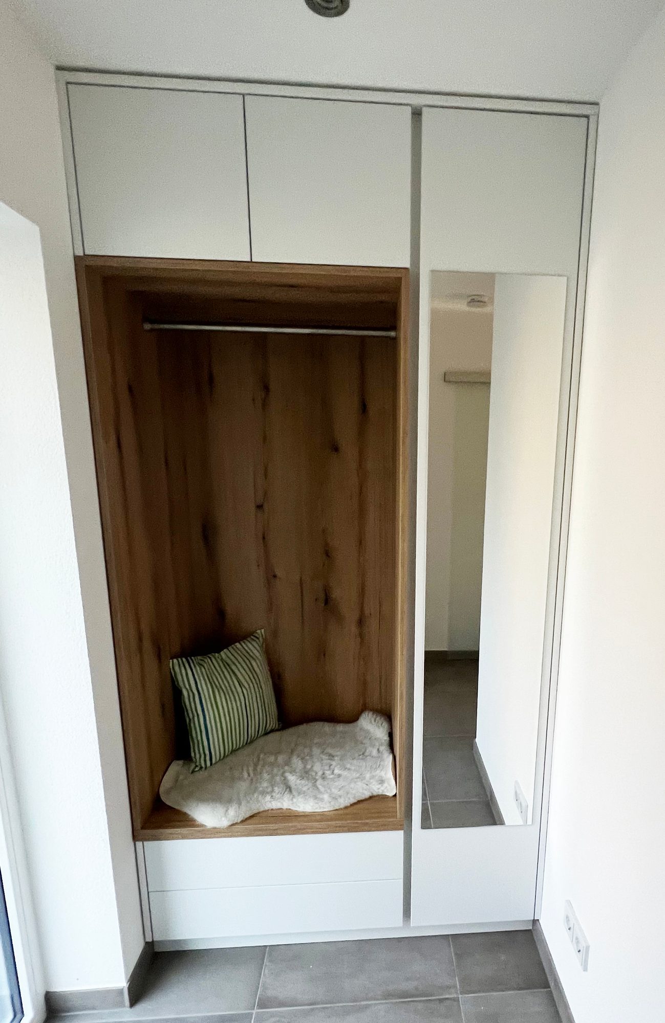 Garderobennische mit Sitzpolster und Spiegeltür