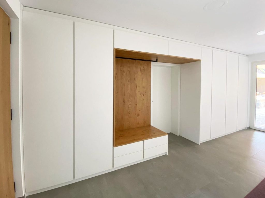 Weiße Garderobenwand mit Sitznische in Holzoptik