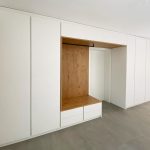 Weiße Garderobenwand mit Sitznische in Holzoptik