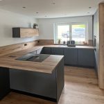Kochtheke mit Kochfeld und Regal in Holzverkleidung