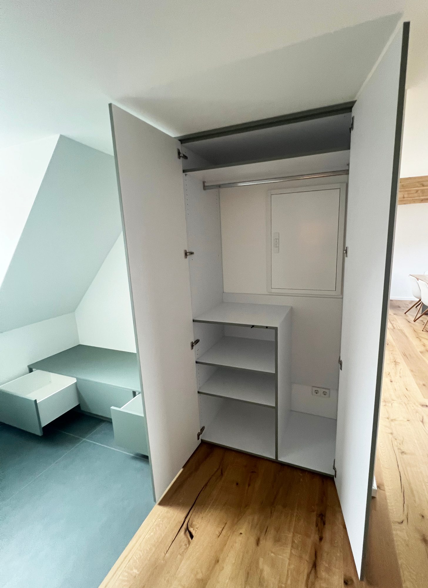 Geöffneter Hochschrank mit Kleiderstange und Fächern
