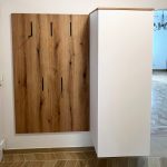Hakenpaneel in Holzoptik neben einem weißen Schuhschrank