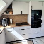 Helle Küche mit Kochfeld, Rückwand in Holzoptik und Hochschränken
