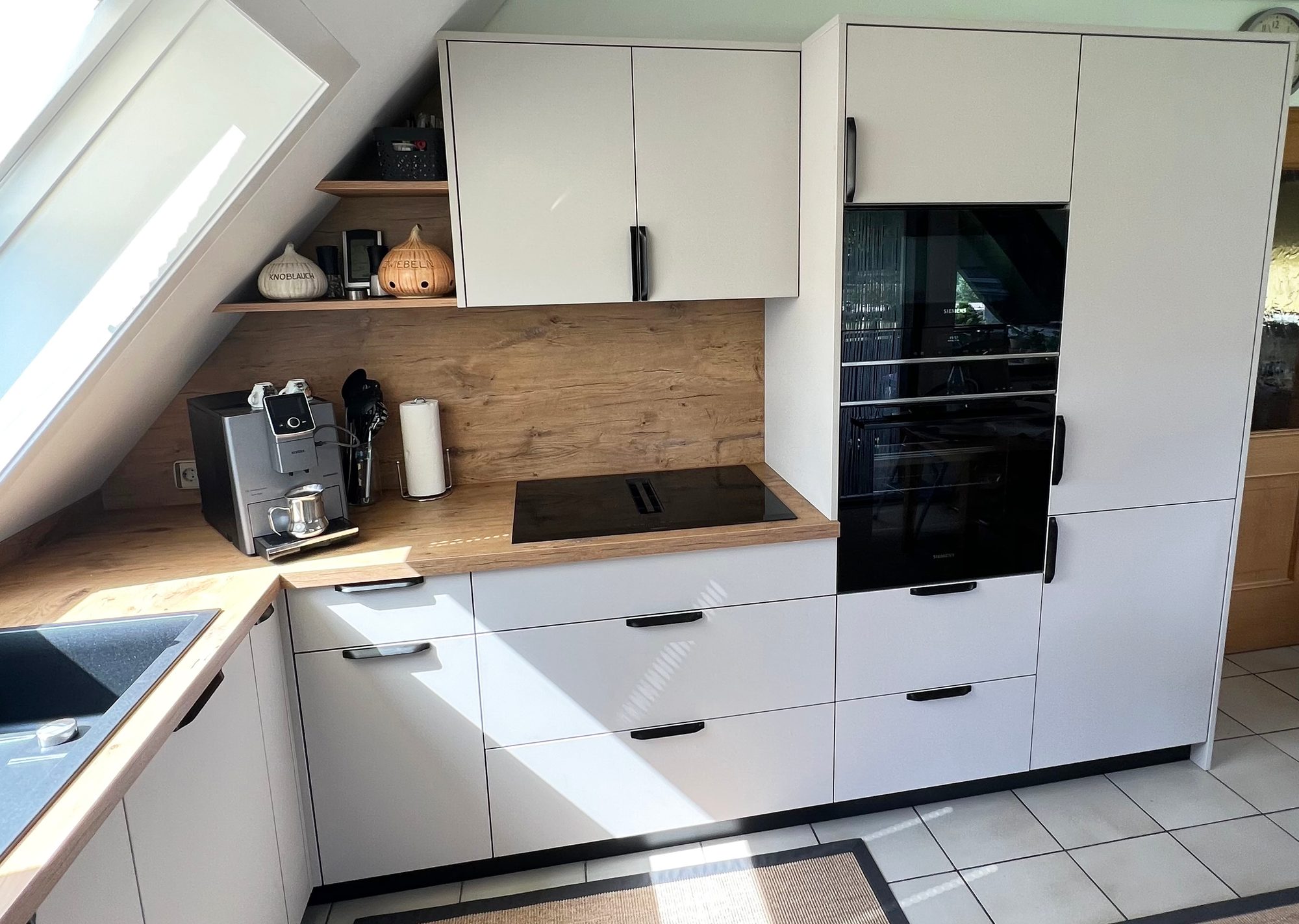 Helle Küche mit Kochfeld, Rückwand in Holzoptik und Hochschränken