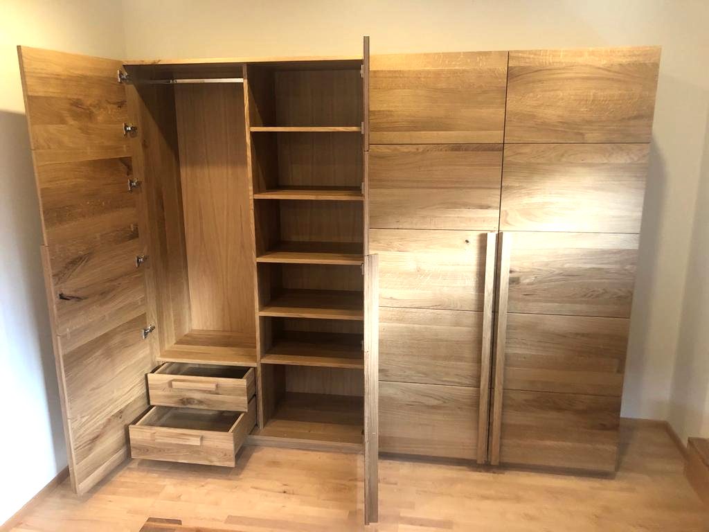 Geöffneter Kleiderschrank aus Holz mit Fächern und Schubladen