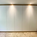 Weißer Kleiderschrank mit Rahmen in Holzoptik und Beleuchtung