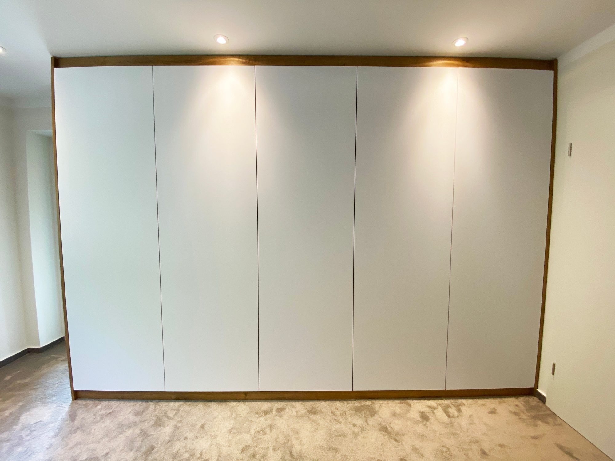 Weißer Kleiderschrank mit Rahmen in Holzoptik und Beleuchtung