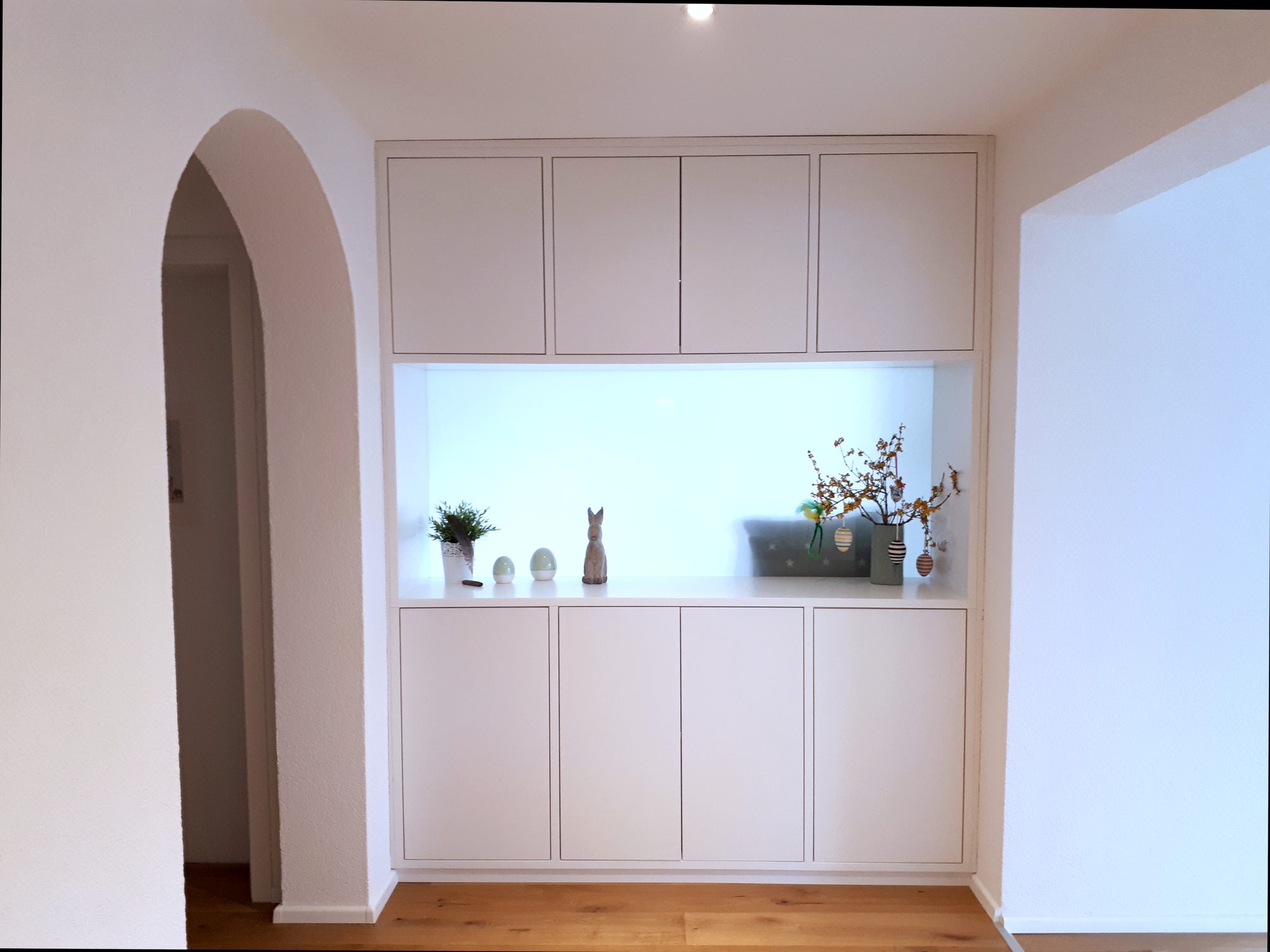 Weißer Wandschrank mit beleuchteter Nische