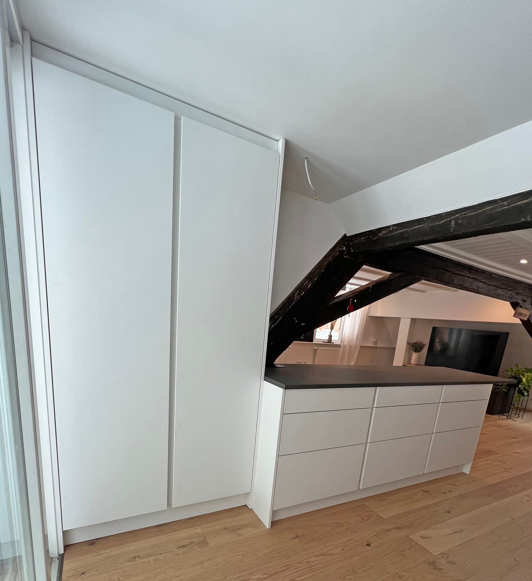 Hochschrank und Theke mit Schubkästen neben dem Dachstuhl