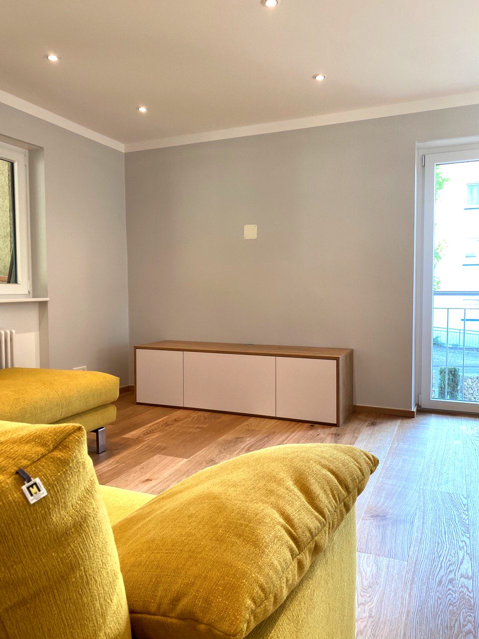Weißes Lowboard mit Wangen in Holzoptik im Wohnzimmer