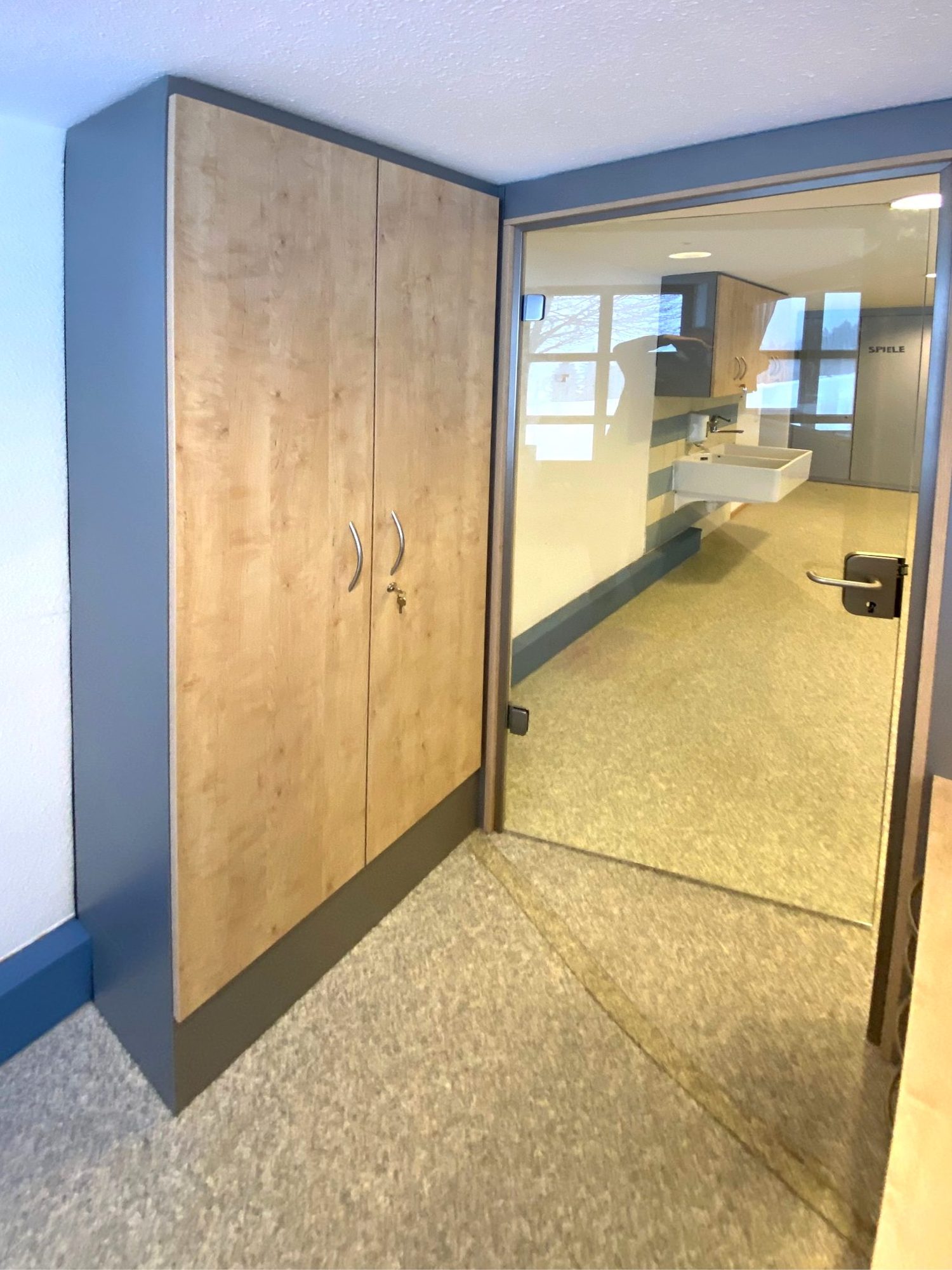 Hoher Schrank in Holzoptik mit grauer Verkleidung