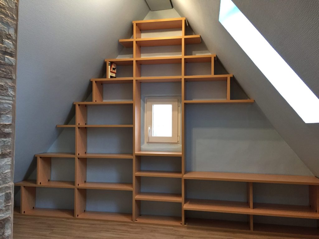 Regal in Holzoptik, das in Stufen der Dachschräge folgt