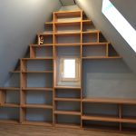Regal in Holzoptik, das in Stufen der Dachschräge folgt
