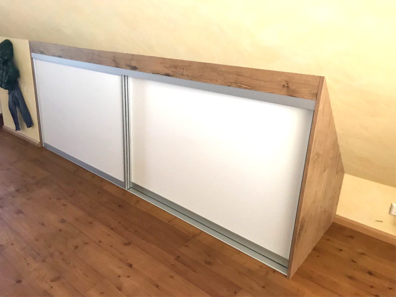Schwebetürenschrank mit Rahmen in Holzoptik unter der Schräge