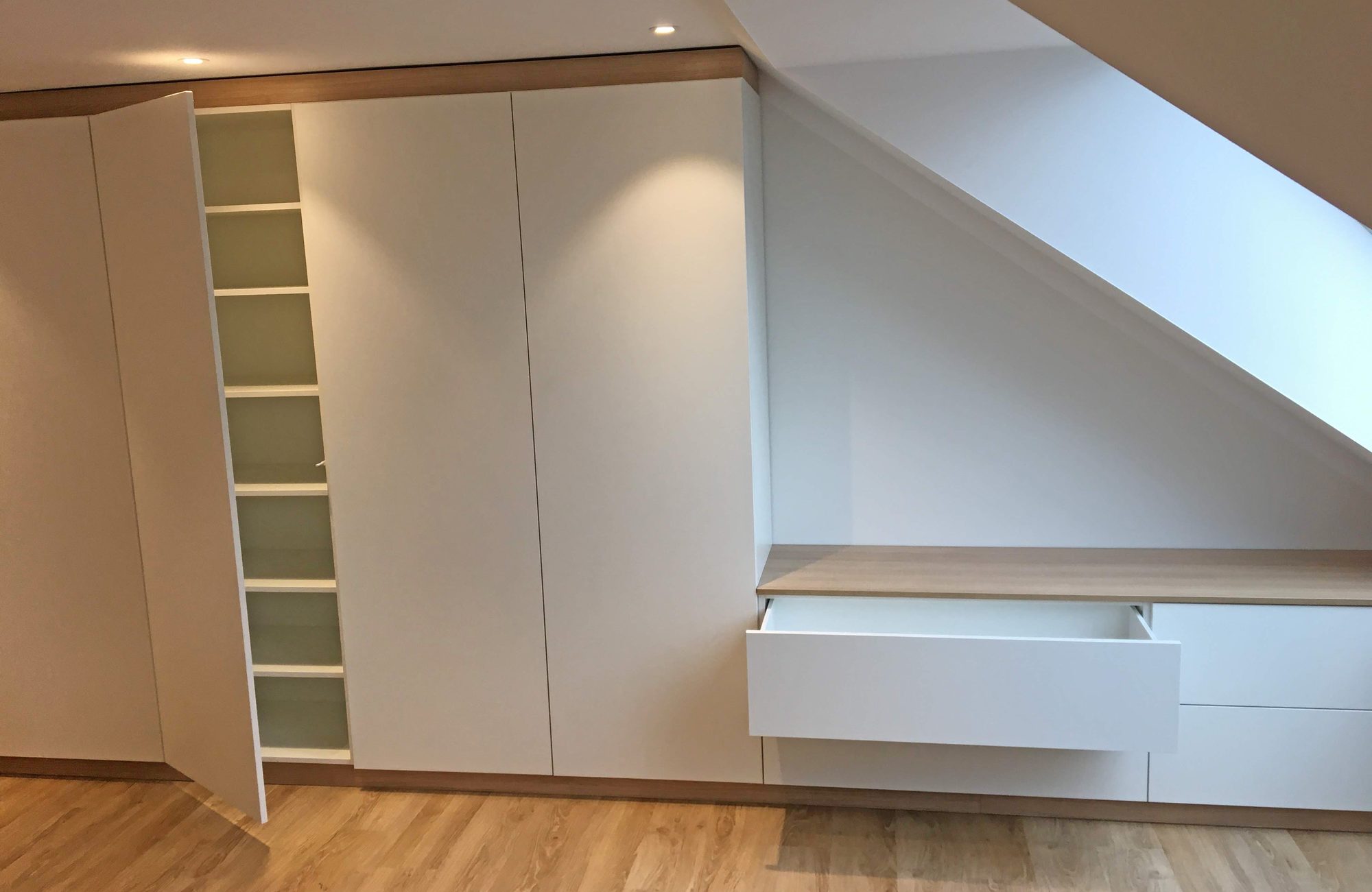 Geöffneter Schrank und Schubkasten unter der Schräge