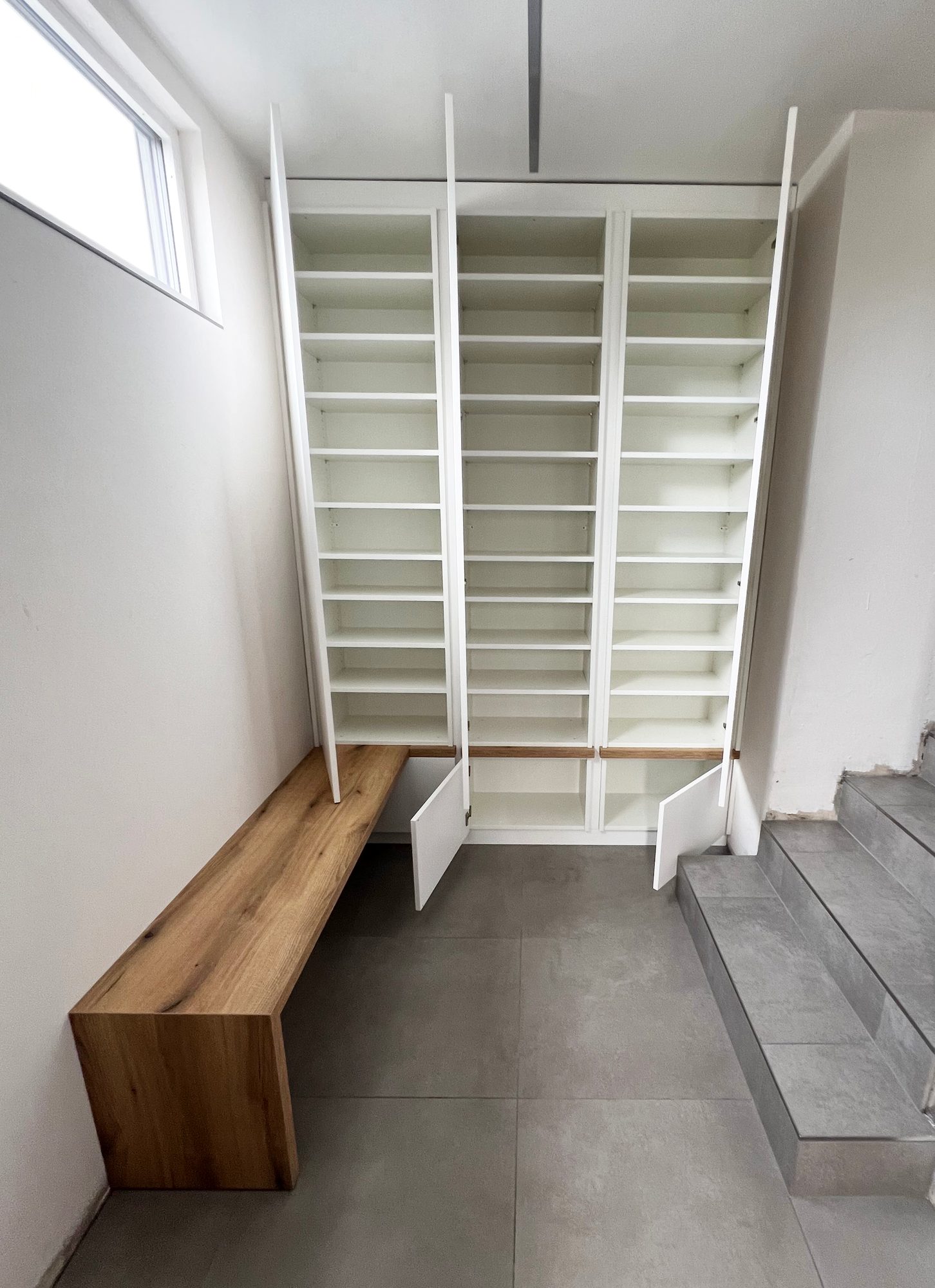 Geöffneter Schuhschrank mit vielen Fachböden