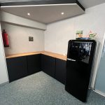 Schwarze Schrankzeile über Eck mit Platte in Holzoptik