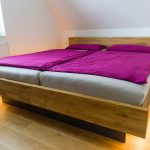 Schwebendes Doppelbett in Holzoptik mit Lichtband