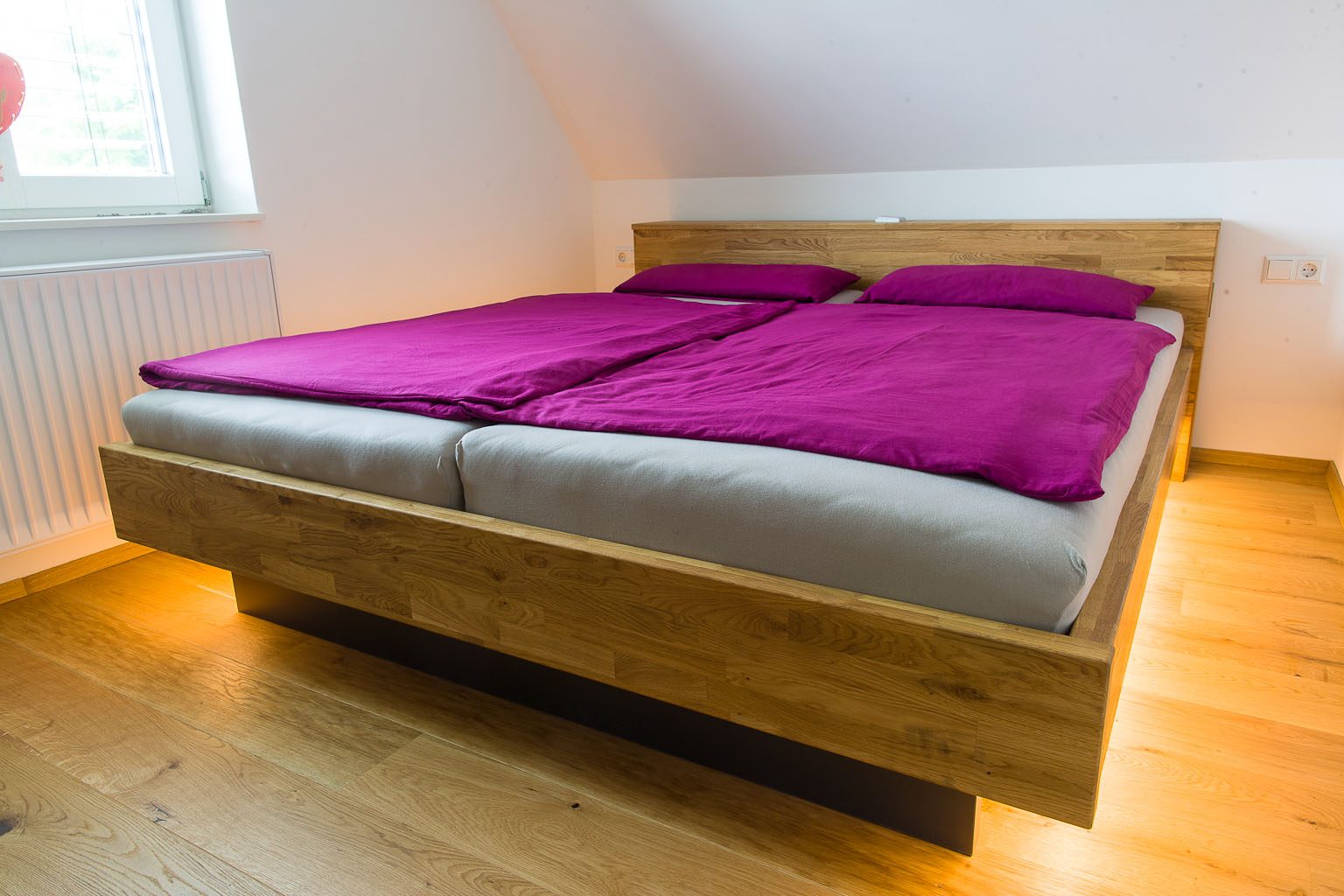 Schwebendes Doppelbett in Holzoptik mit Lichtband