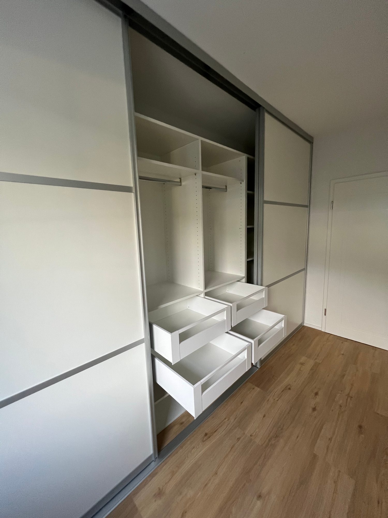 Schwebetürenschrank mit geöffneten Auszügen