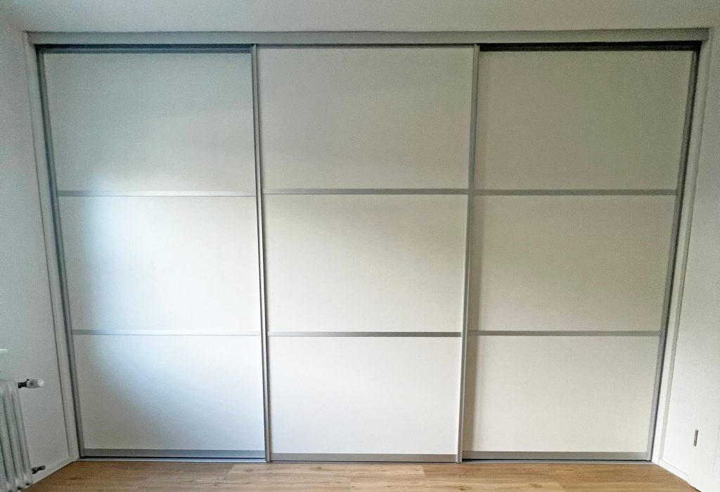 Geschlossener weißer Schwebetürenschrank