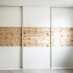 Weißer Schwebetürenschrank mit durchgehendem Holzband