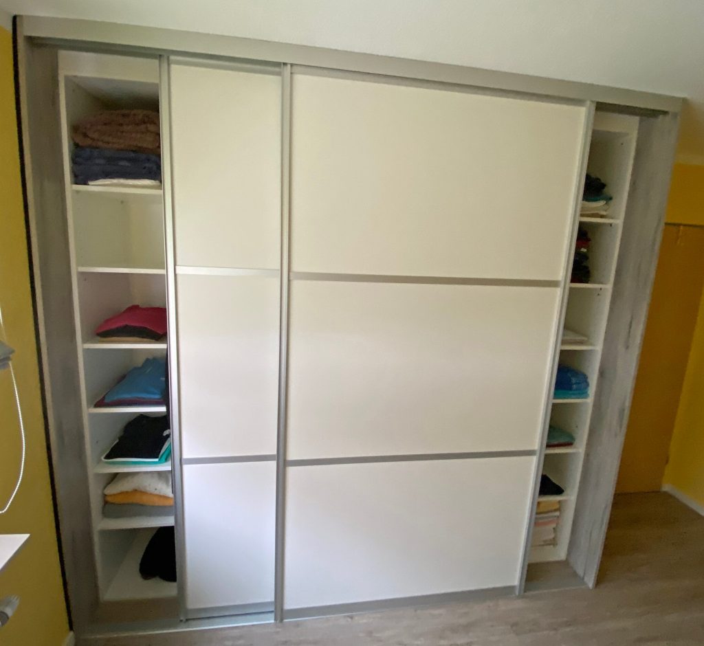 Schwebetürenschrank mit offenen Regalen an den Seiten
