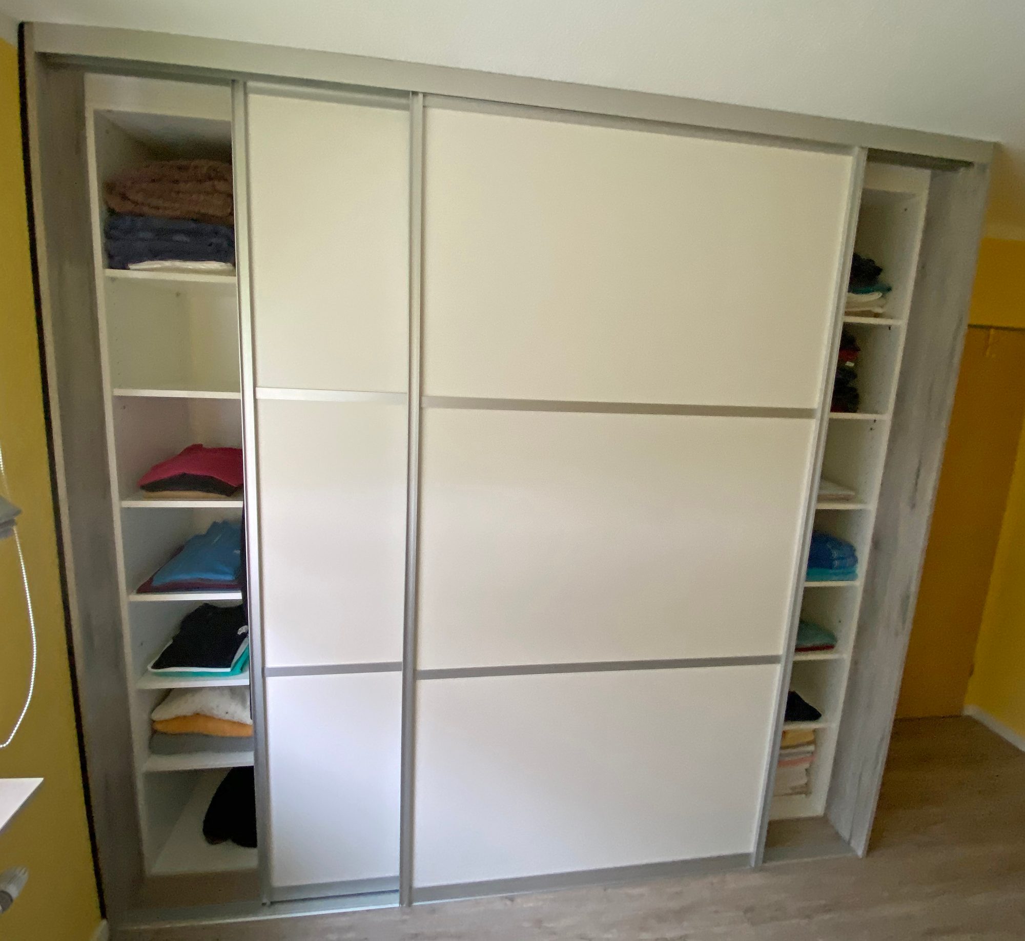 Schwebetürenschrank mit offenen Regalen an den Seiten